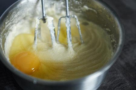 Beat the eggs in a stainless steel bowl with a whisk. Preparing the cake batter.