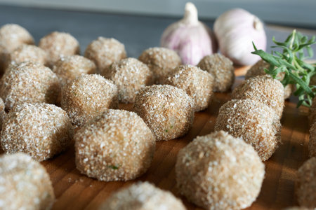 Meatballs with garlic and thyme on a wooden board.