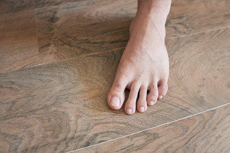 Close up of a man's foot on a wooden floor. Selective focus.