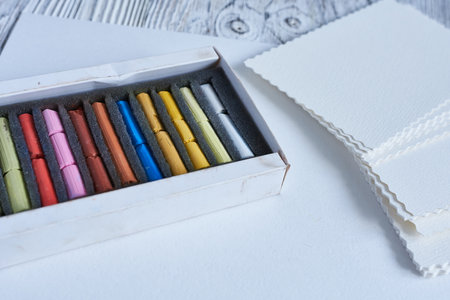 Set of pastel crayons in a box on wooden backgroundの写真素材