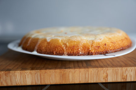 Lemon bundt cake on a white plate on a wooden board