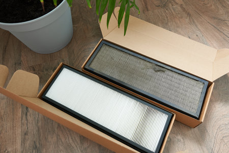 Air filter in cardboard box on wooden table, top view. Space for textの写真素材