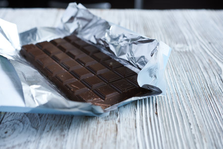 chocolate bar in foil on a wooden background. selective focus.の写真素材