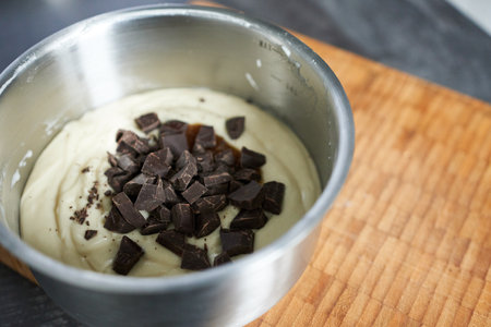 Creamy vanilla batter with chocolate chips in a stainless steel bowl.