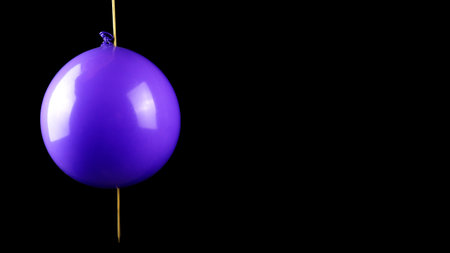 one hand shows the action of stabbing a balloon using a skewer without exploding. The concept of science using balloonsの写真素材