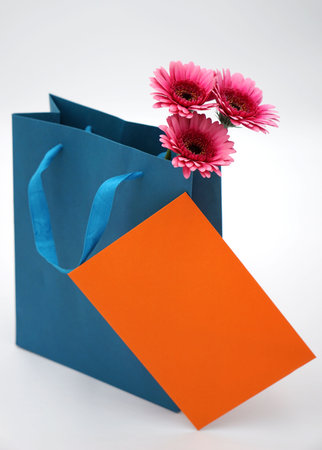 Pink gerbera flower in a blue bag on a white backgroundの写真素材