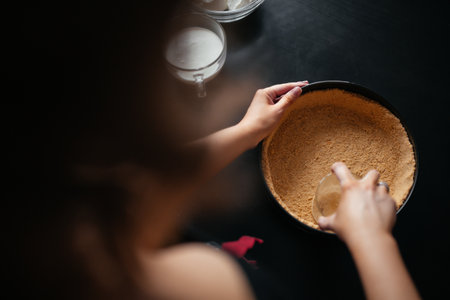 Girl molds crushed cracker in a baking dishの写真素材