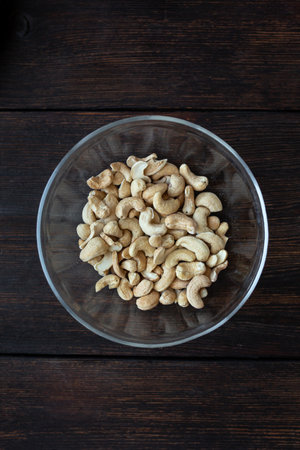 cashew nuts in a plate on a black wooden table top viewの写真素材