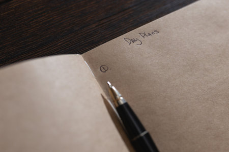 Notepad with the inscription on the page Day plans with a pen