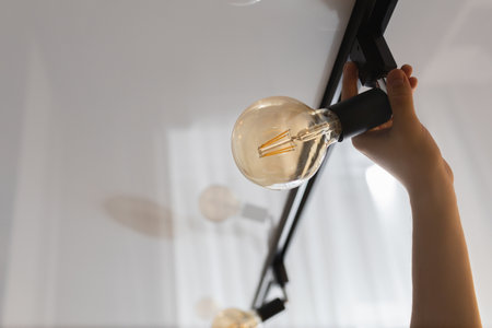 A man changes a burnt out light bulb at home