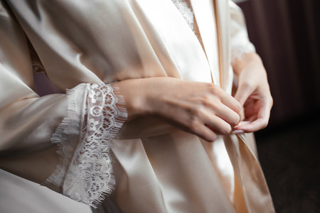 the girl straightens the belt of the pajamas robeの写真素材