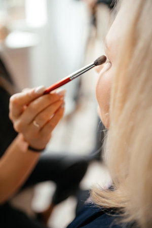 a woman has a brush applied to her eyelidsの写真素材