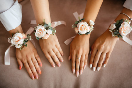 hands of four women with tied flowers on their handsの写真素材