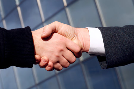 Handshake outdoors in front of office building.の写真素材