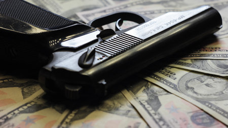 Gun and dollars as sign of organized crime.