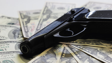 Gun and dollars as sign of organized crime.