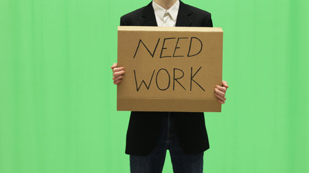Unemployed businessman looking for work with a sign in hands.の写真素材