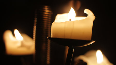 Detail of candelabra with burning candles low key.