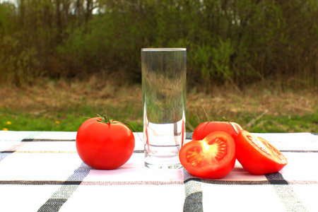 Tomatoes and empty juice glass outdoors.の写真素材