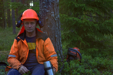Lumberjack resting under tree after hard work.