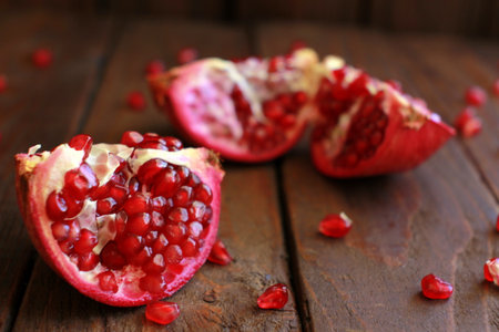 Pomegranate Pieces Scattered on Wooden Backgroundの写真素材