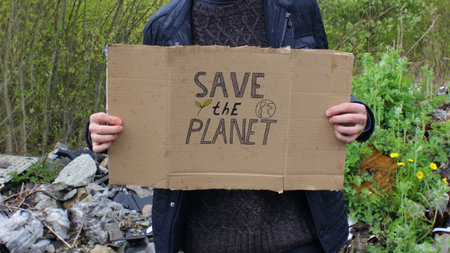 Man with Save the Planet Sign and Landfill in the Backgroundの写真素材
