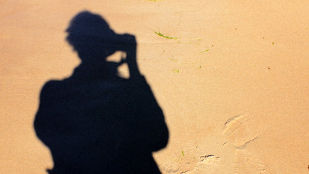 Silhouette of Man with Photo Camera Making a Photo of Himself on Sand