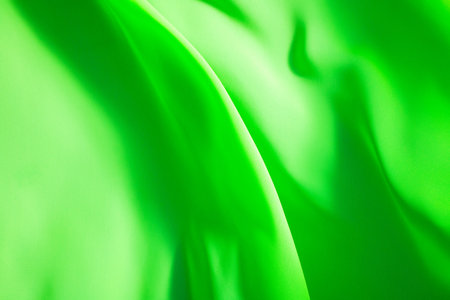 green fabric winds waves, creating a beautiful background of the foldsの写真素材