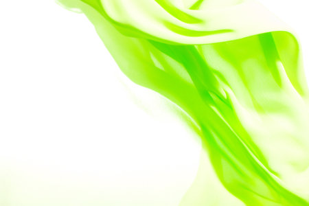 green fabric winds waves, creating a beautiful background of the foldsの写真素材