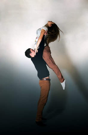 A young man holding his girlfriend on handsの写真素材