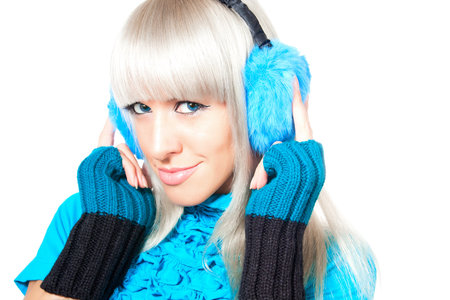 Beautiful blonde in a warm jacket, warm gloves and fur earmuffsの写真素材