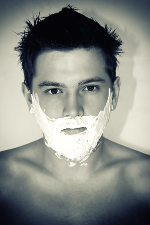 The man with the put shaving cream on faceの写真素材
