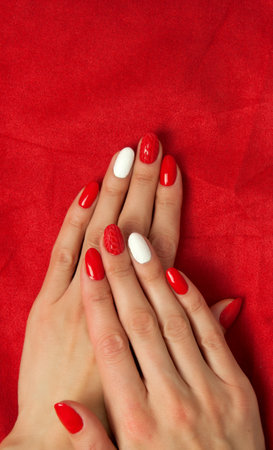 Female hands with a beautiful red manicure, on the backgroundの写真素材