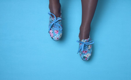 sneakers with floral print on the background of women's shirt with bright colors