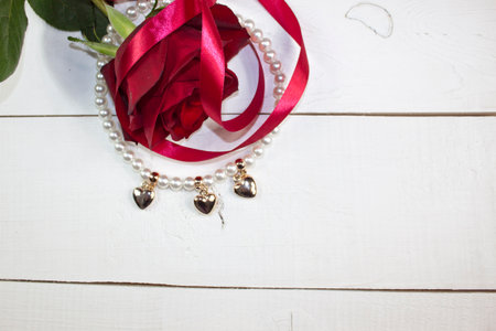 Pearl necklace with golden hearts on white woodの写真素材