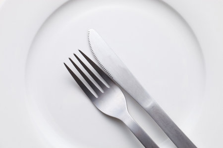 White empty plate with fork and knife 