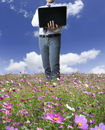 man holding laptop over his head on white background の写真素材