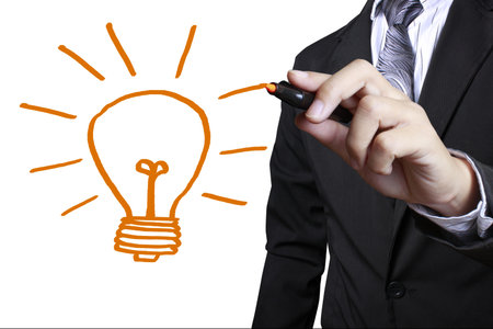 hand with a pen drawing light bulb の写真素材