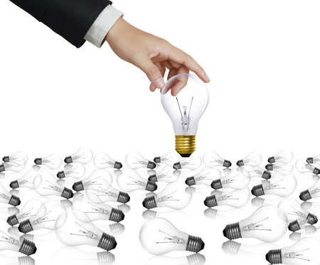 light bulb held between fingers の写真素材