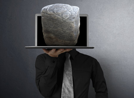 business man holding a laptop and Stone の写真素材