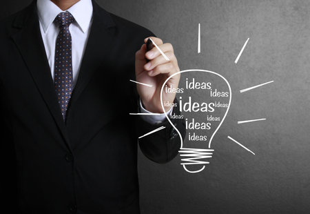 Business man drawing light bulb の写真素材