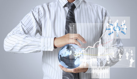 holding glowing earth globe and  financial symbols coming from hand の写真素材