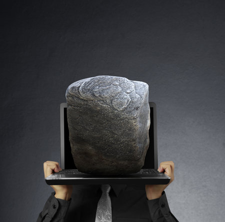 business man holding a laptop and Stone の写真素材