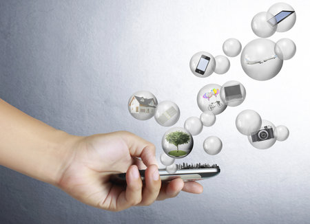 Touch screen mobile phone in hand with businessmen の写真素材