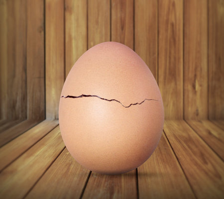 Broken egg isolated on wood background 