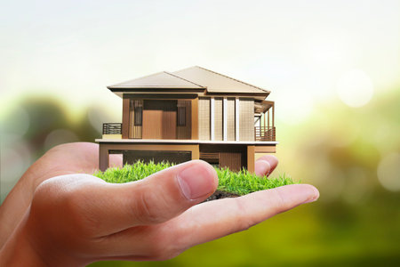 Business man house in human hands 