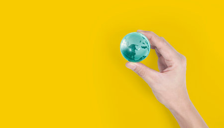 Globe, earth in human hand, holding our planet glowing.の写真素材
