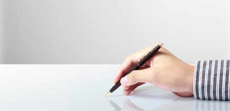 Pen in hand on a white backgroundの写真素材
