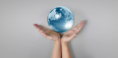 Globe, earth in human hand, holding our planet glowing.の写真素材