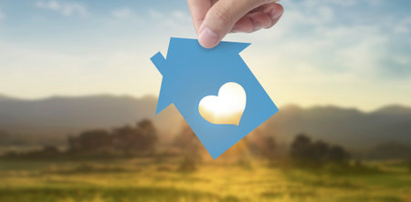 Hands holding paper house, family home and protecting insurance conceptの写真素材